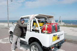 出発地の宗谷岬で、手作り電気自動車をチェックする鈴木代表